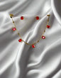 Gold station necklace and earrings jewelry set with rectangular ruby red stones in minimalist geometric design displayed on black velvet stand