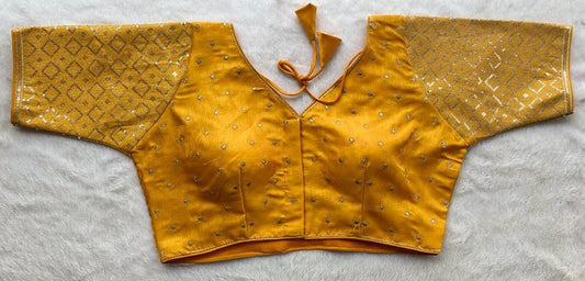 Designer Milan silk readymade blouse with embroidery, back dori tie-up, and padded comfort, displayed flat on fabric backdrop.
