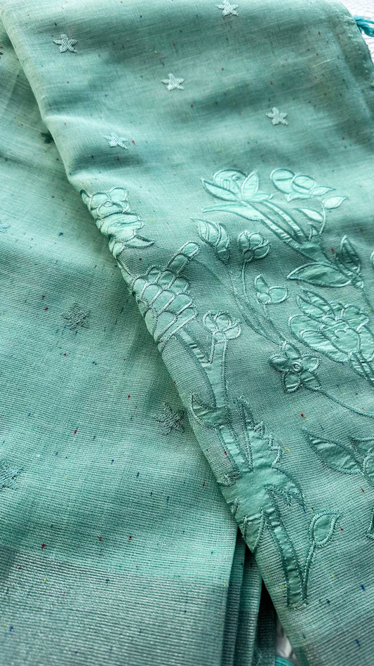 Light blue linen saree featuring floral appliqué embroidery with tassel detailing on the pallu.