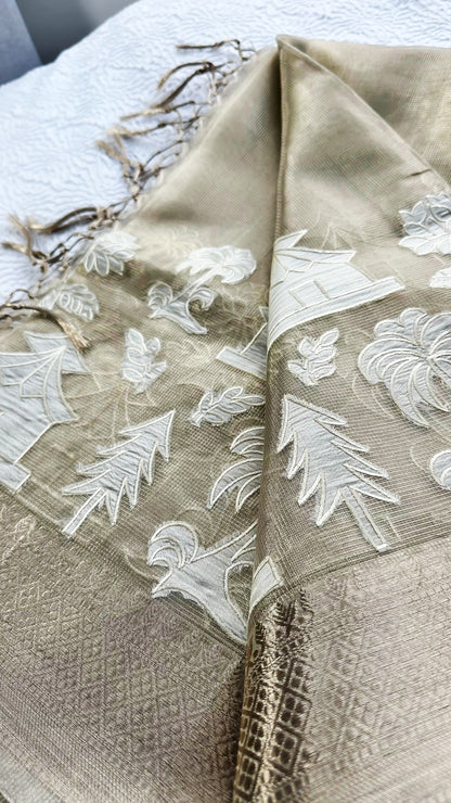 Fancy tissue saree with non-floral appliqué embroidery and tassel pallu in a soft, glossy finish.