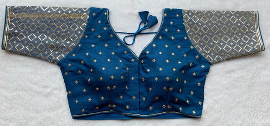 Designer Milan silk readymade blouse with embroidery, back dori tie-up, and padded comfort, displayed flat on fabric backdrop.
