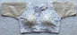 Designer Milan silk readymade blouse with embroidery, back dori tie-up, and padded comfort, displayed flat on fabric backdrop.
