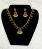 Traditional Indian gold chandbali necklace and earrings jewelry set with ruby stones pearl drops and kundan work in elaborate bridal design displayed on black velvet stand