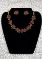 Traditional Indian gold lotus necklace and earrings jewelry set with ruby kundan work and spiritual lotus flower motifs displayed on black velvet stand